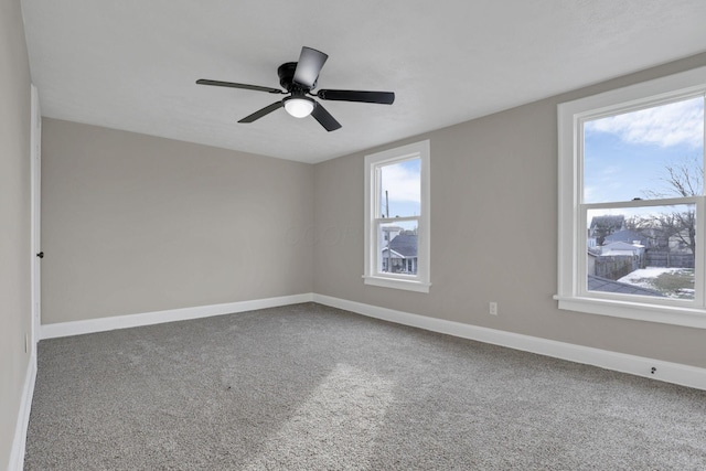 carpeted spare room featuring ceiling fan