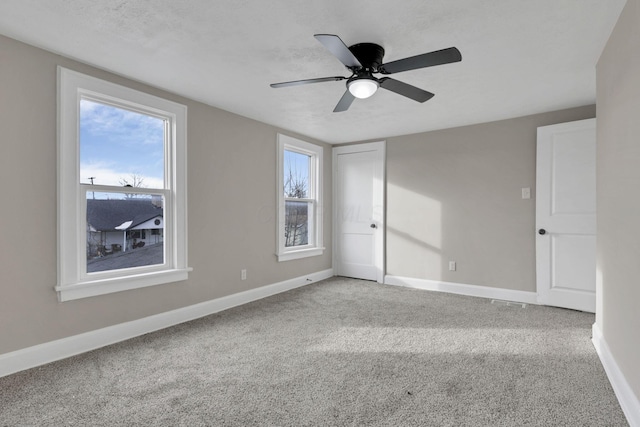 carpeted spare room with ceiling fan and a textured ceiling