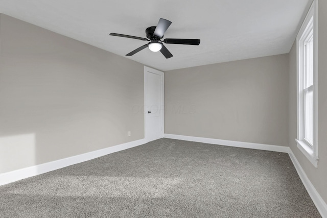 empty room featuring ceiling fan and carpet