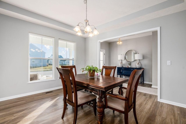 dining room featuring hardwood / wood-style floors and a notable chandelier