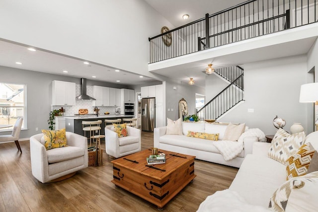 living room featuring a towering ceiling and light hardwood / wood-style floors