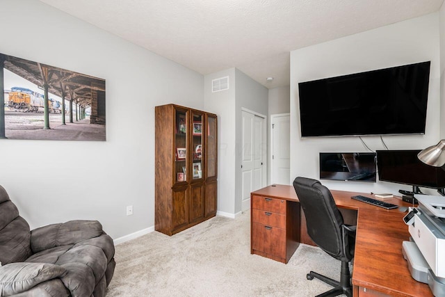 carpeted home office featuring a textured ceiling