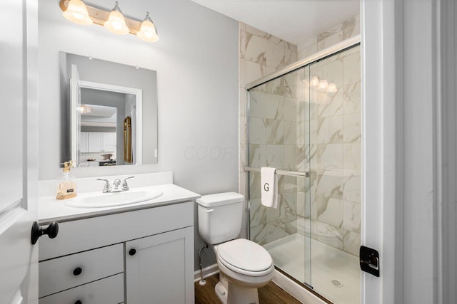 bathroom with walk in shower, vanity, and toilet