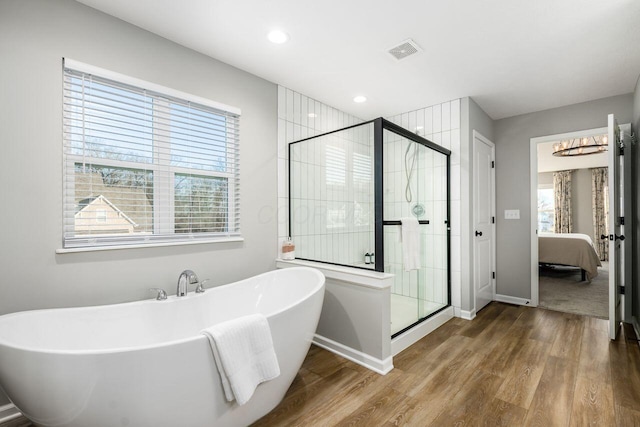 bathroom with wood-type flooring and separate shower and tub