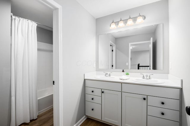 bathroom with vanity, hardwood / wood-style floors, and shower / bath combo with shower curtain