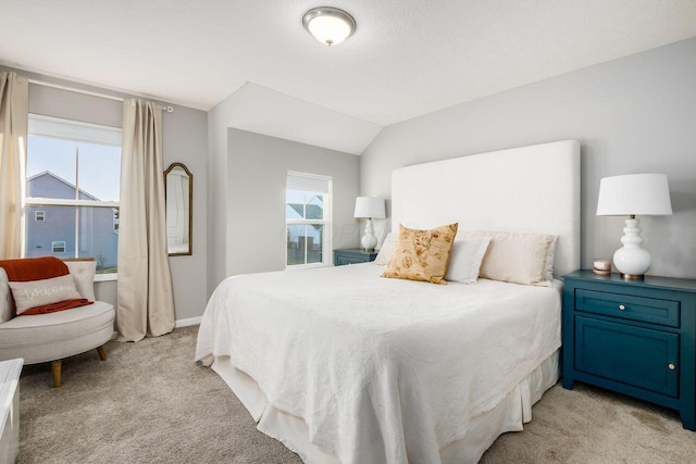 carpeted bedroom featuring multiple windows and lofted ceiling