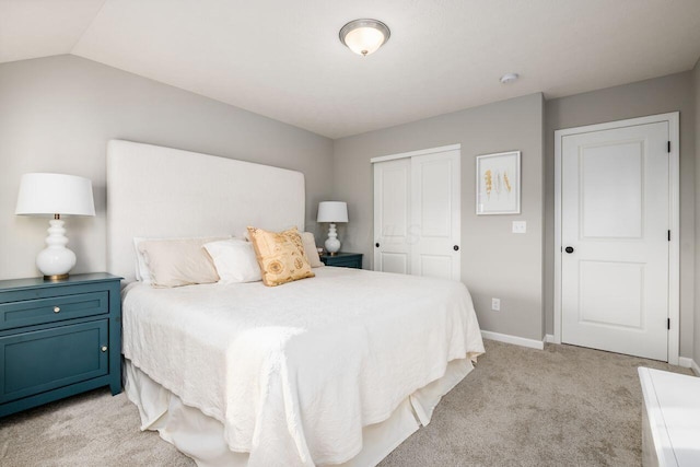 bedroom with light carpet, vaulted ceiling, and a closet