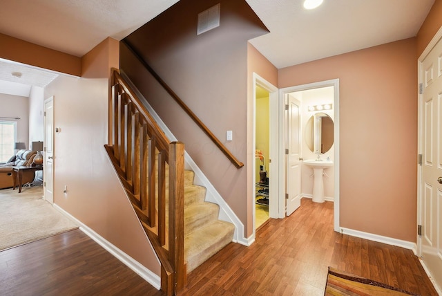 stairway featuring hardwood / wood-style flooring and sink