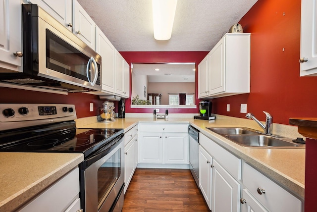 kitchen with stainless steel appliances, sink, white cabinets, and a textured ceiling