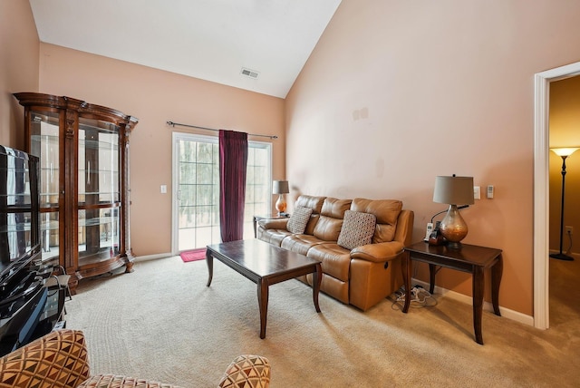 carpeted living room featuring high vaulted ceiling