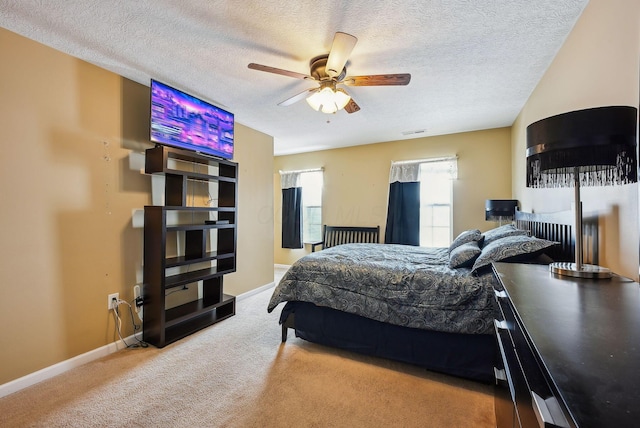 bedroom featuring light carpet, a textured ceiling, and ceiling fan