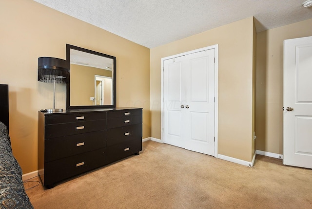 bedroom with light colored carpet, a closet, and a textured ceiling