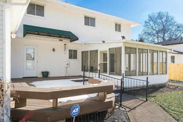 back of property with a sunroom and a deck