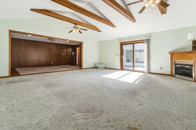 unfurnished living room featuring ceiling fan, high vaulted ceiling, beam ceiling, and carpet floors