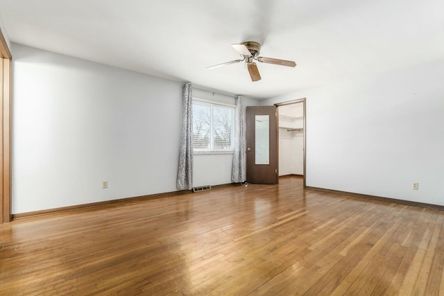 empty room with ceiling fan and light hardwood / wood-style flooring