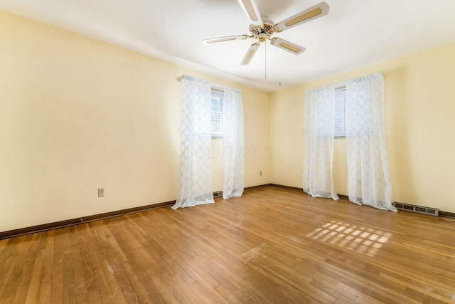 empty room with hardwood / wood-style flooring and ceiling fan