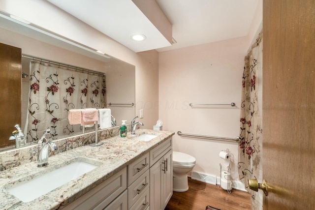 bathroom featuring wood-type flooring, curtained shower, vanity, and toilet