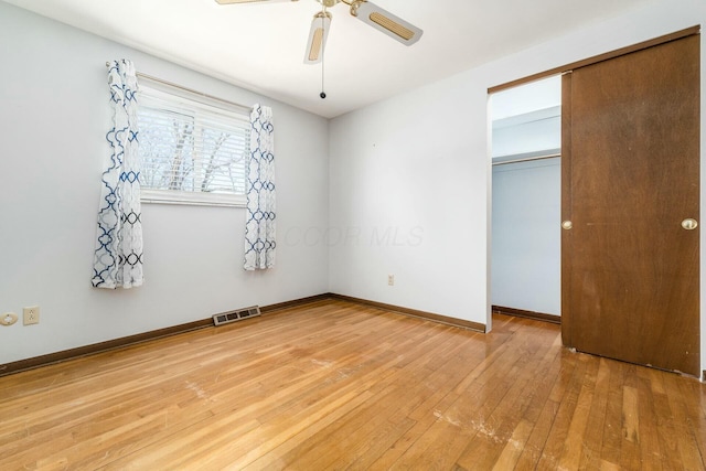 unfurnished bedroom featuring hardwood / wood-style flooring, a closet, and ceiling fan