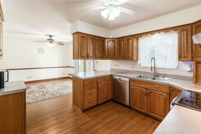 kitchen featuring dishwasher, sink, ceiling fan, kitchen peninsula, and light wood-type flooring