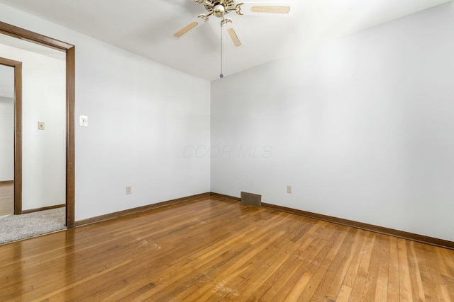 empty room with hardwood / wood-style floors and ceiling fan