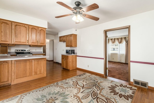 kitchen with dark hardwood / wood-style floors, ceiling fan, and appliances with stainless steel finishes