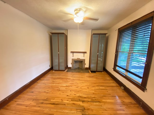 spare room featuring ceiling fan, light hardwood / wood-style floors, and a textured ceiling