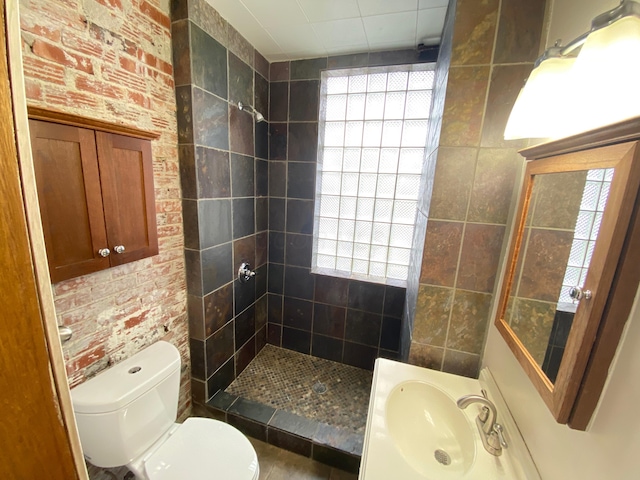 bathroom with a wealth of natural light, a tile shower, sink, tile walls, and toilet