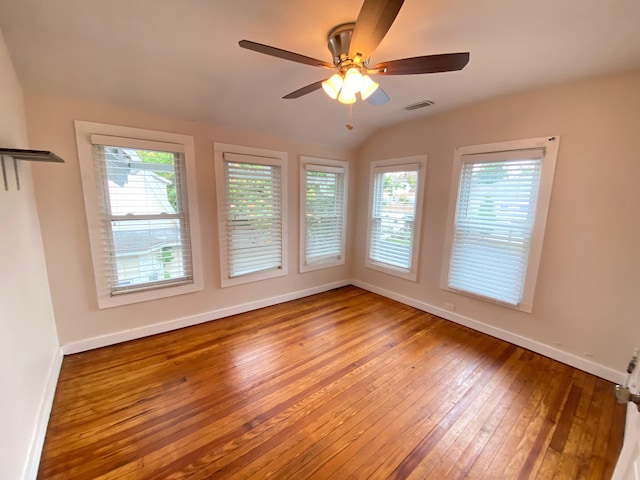 spare room featuring wood-type flooring, vaulted ceiling, and ceiling fan