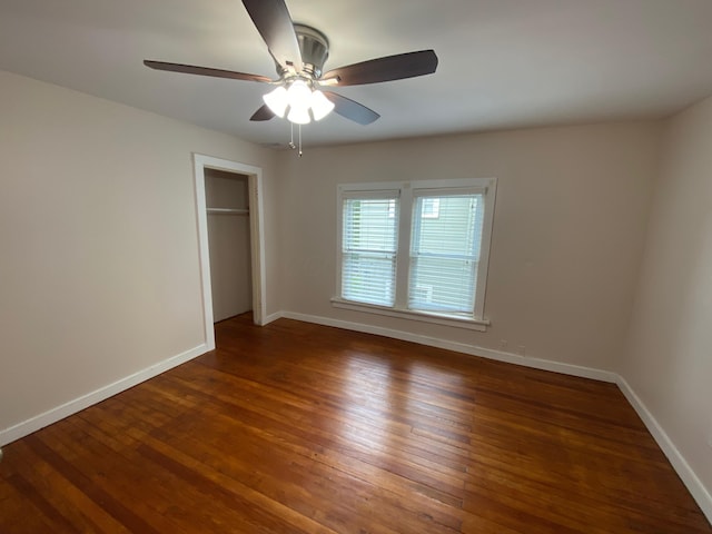 unfurnished bedroom featuring ceiling fan, dark hardwood / wood-style floors, and a closet