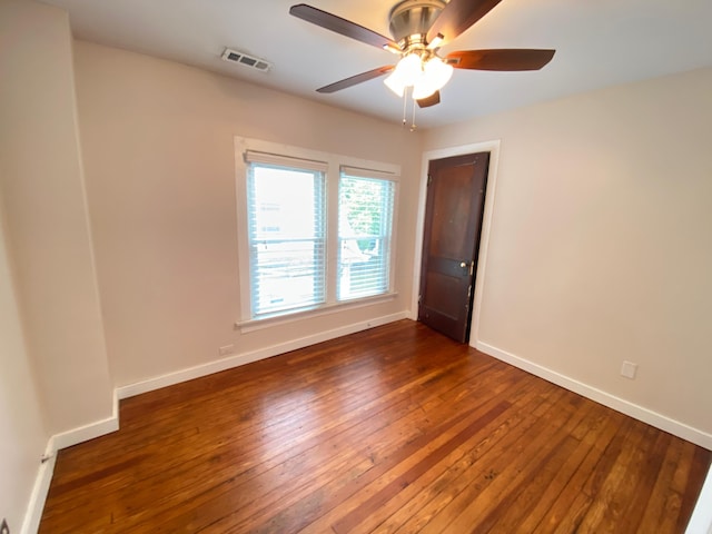 spare room featuring ceiling fan and dark hardwood / wood-style flooring