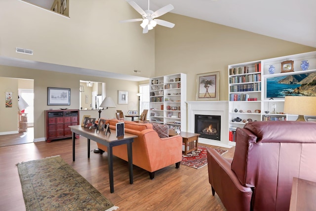 living room featuring light wood-type flooring, high vaulted ceiling, and ceiling fan