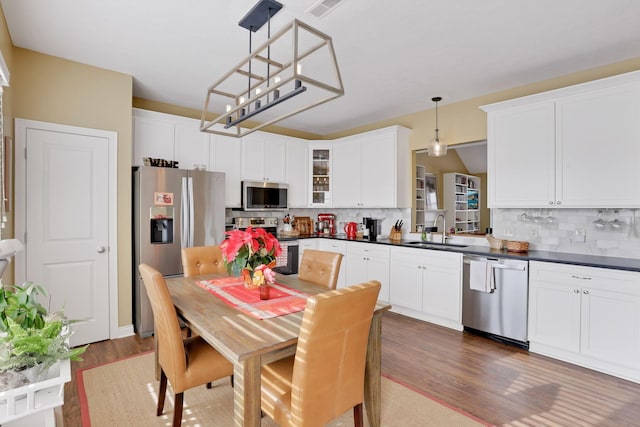 kitchen featuring sink, stainless steel appliances, tasteful backsplash, and decorative light fixtures