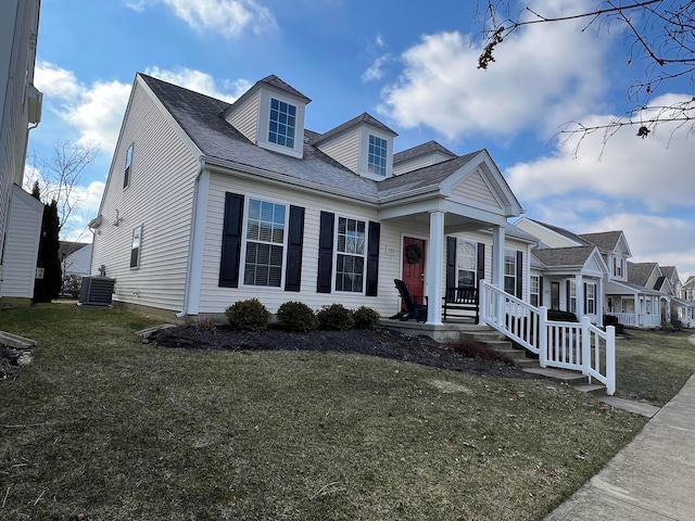 new england style home featuring central AC unit and a front yard