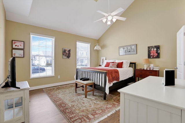 bedroom featuring hardwood / wood-style flooring, high vaulted ceiling, and ceiling fan