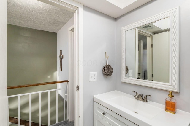 bathroom with vanity and a textured ceiling