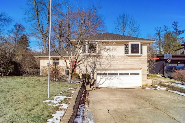 tri-level home featuring a garage and a front lawn