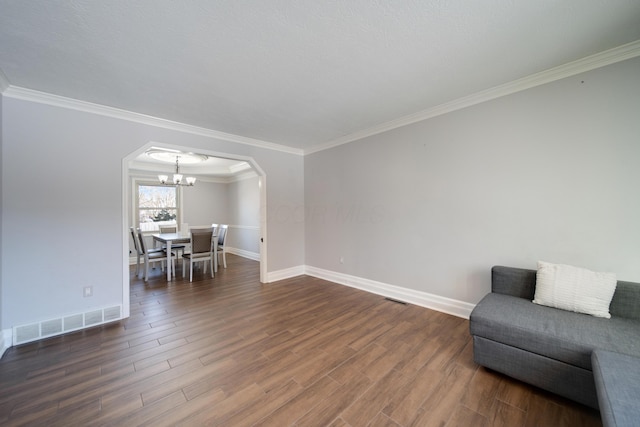 interior space featuring an inviting chandelier, crown molding, and dark wood-type flooring