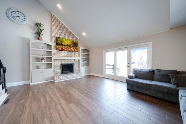 unfurnished living room with high vaulted ceiling, hardwood / wood-style floors, and a fireplace