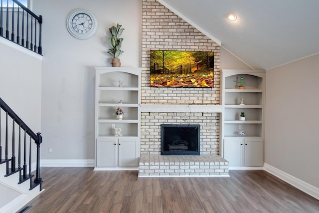 unfurnished living room with lofted ceiling, hardwood / wood-style floors, and a brick fireplace