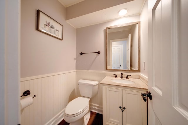 bathroom featuring vanity, crown molding, and toilet