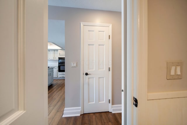 hallway with dark hardwood / wood-style flooring