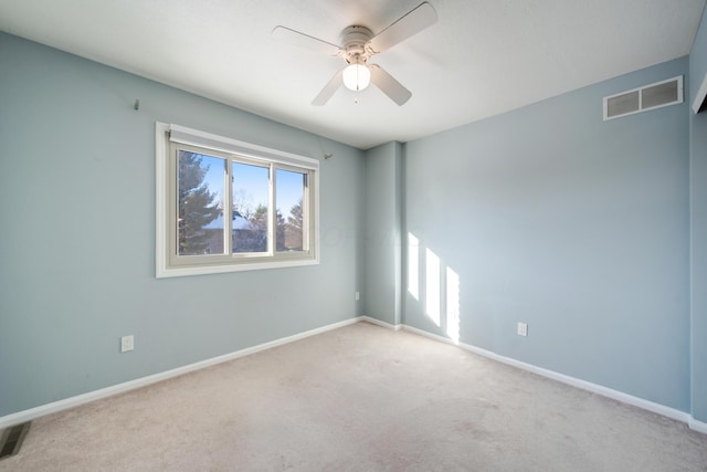 carpeted spare room with ceiling fan