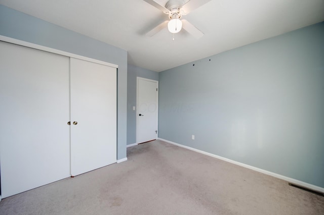 unfurnished bedroom with light carpet, ceiling fan, and a closet