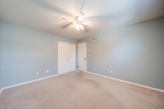 carpeted spare room with ceiling fan