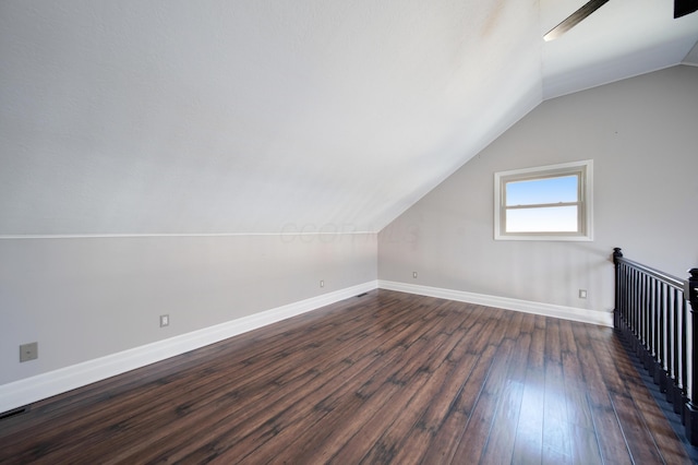 bonus room with ceiling fan, dark hardwood / wood-style flooring, and vaulted ceiling