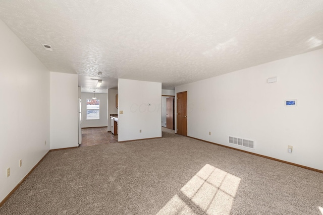 unfurnished room featuring carpet floors and a textured ceiling