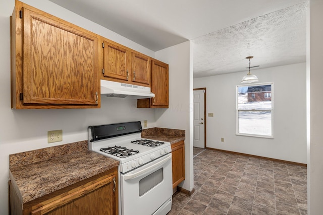 kitchen featuring white range with gas stovetop, a textured ceiling, and decorative light fixtures