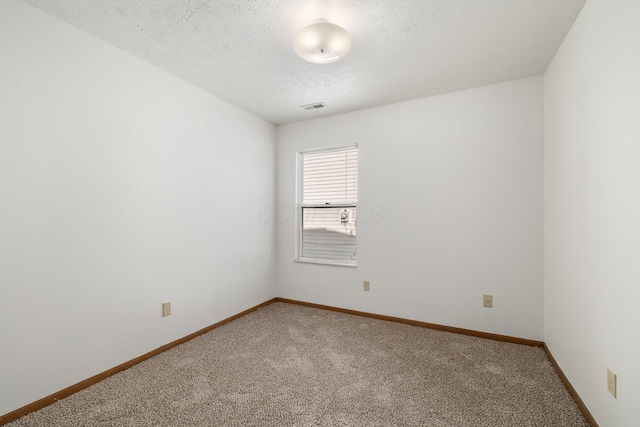 carpeted spare room featuring a textured ceiling