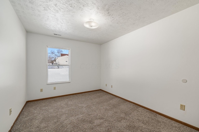 empty room with carpet floors and a textured ceiling