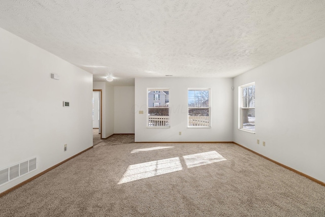 carpeted empty room with a textured ceiling